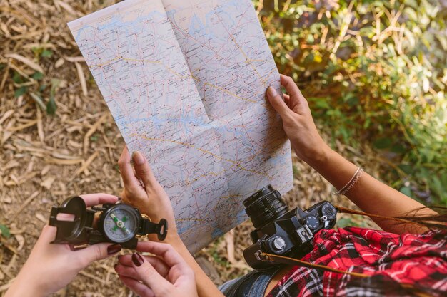 Vista elevada de dos mujeres con brújula y mapa