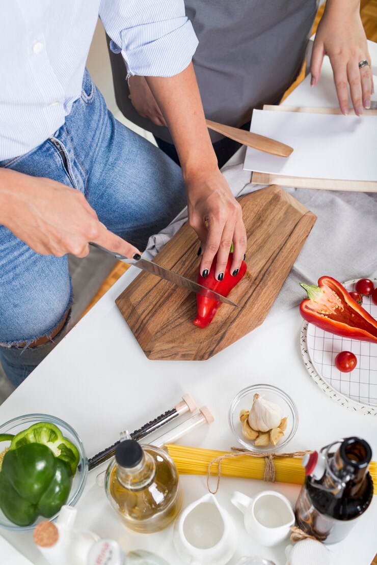 Foto gratuito vista elevada de dos mujeres preparando la comida en la cocina.