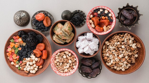 Una vista elevada de dulces tradicionales; Frutos secos y nueces sobre fondo blanco