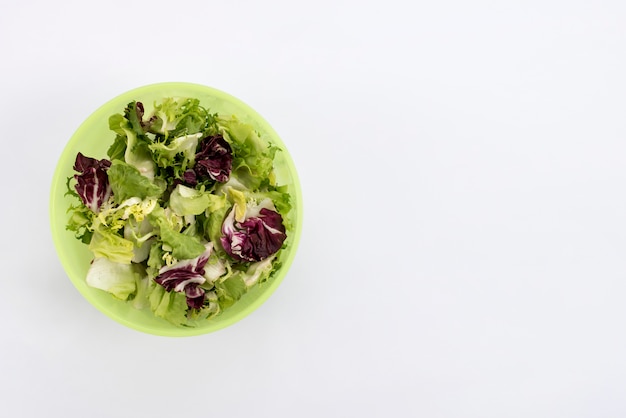 Vista elevada de ensalada saludable en un tazón sobre fondo blanco