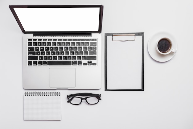 Vista elevada del escritorio de oficina y una taza de café y una computadora portátil abierta