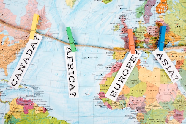 Vista elevada de la etiqueta de nombres de diferentes continentes con pinza de ropa en el mapa