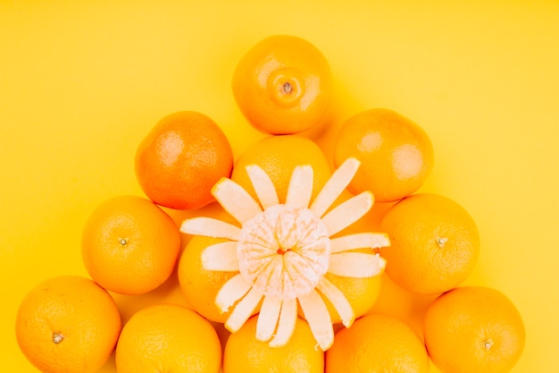 Foto gratuita una vista elevada de una fruta naranja sobre fondo amarillo