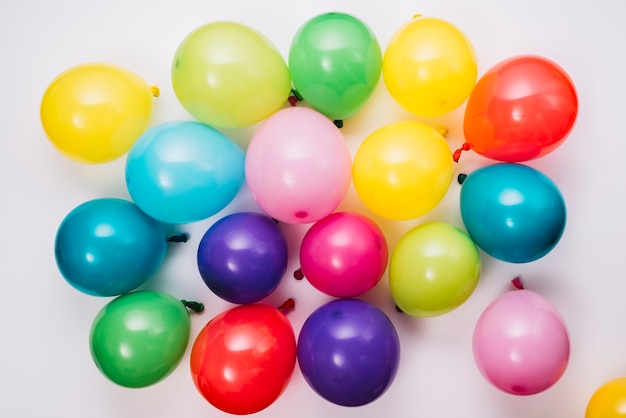 Una vista elevada de globos inflados de colores sobre fondo blanco