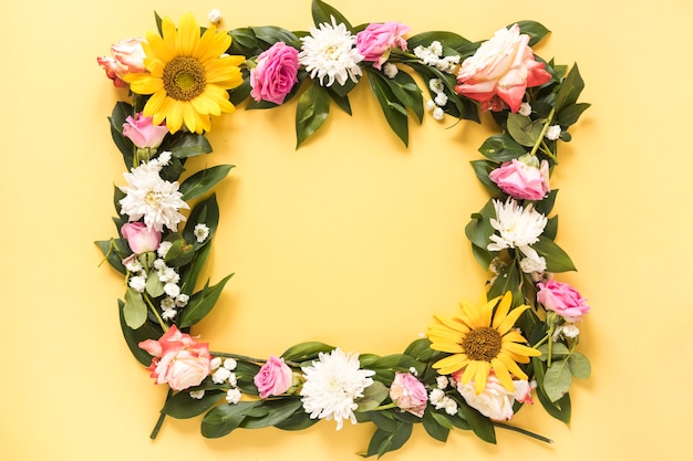 Foto gratuita vista elevada de hermosas flores frescas que forman el marco sobre fondo amarillo