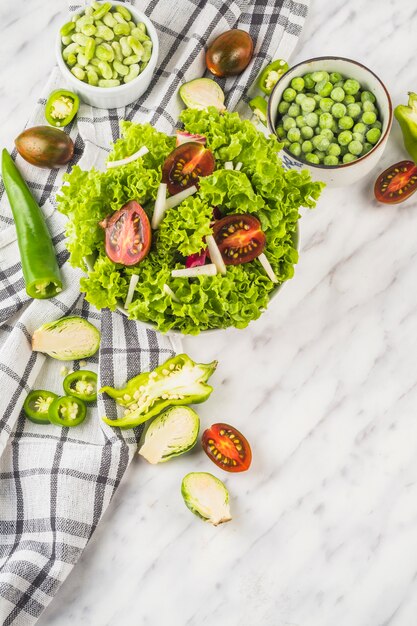 Vista elevada de un ingrediente saludable de ensalada verde sobre fondo de mármol