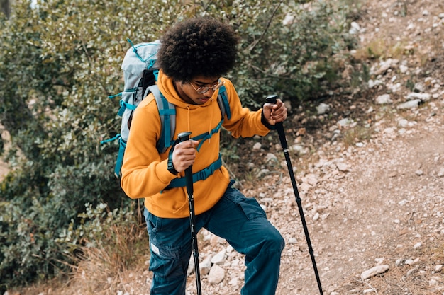 Foto gratuita una vista elevada de un joven africano senderismo en la montaña