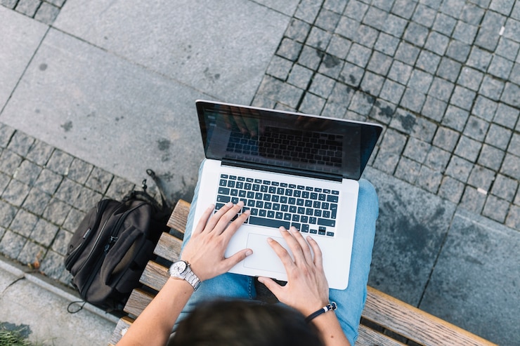 Foto gratuito vista elevada de la mano de un hombre usando una computadora portátil