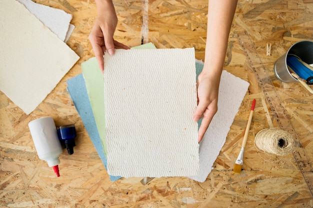 Foto gratuita vista elevada de una mano de mujer con papel hecho a mano