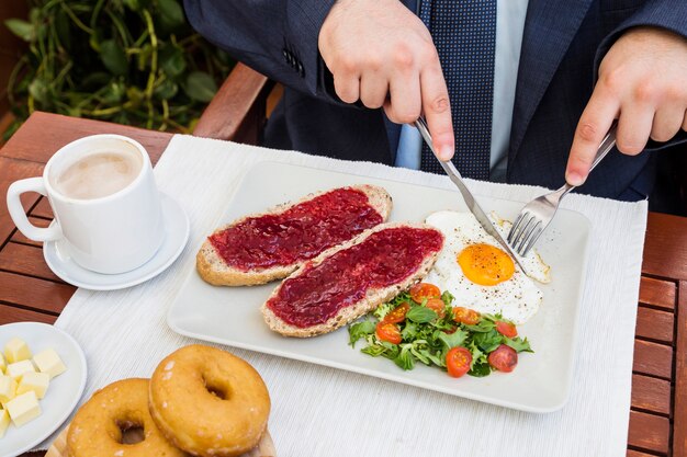 Vista elevada de la mano de una persona que come un desayuno saludable