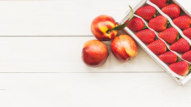 Vista elevada de manzanas y fresas en el fondo de madera