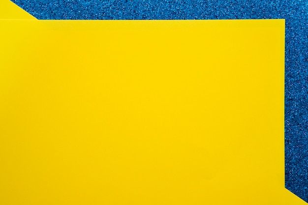 Foto gratuita vista elevada de papeles de cartón amarillo sobre superficie azul