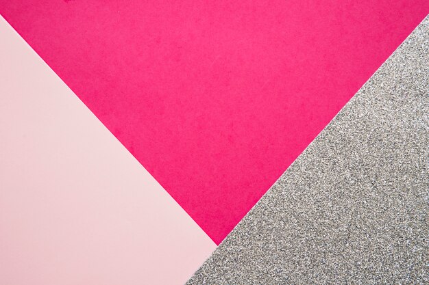 Vista elevada de papeles de cartón rosa y magenta en superficie gris