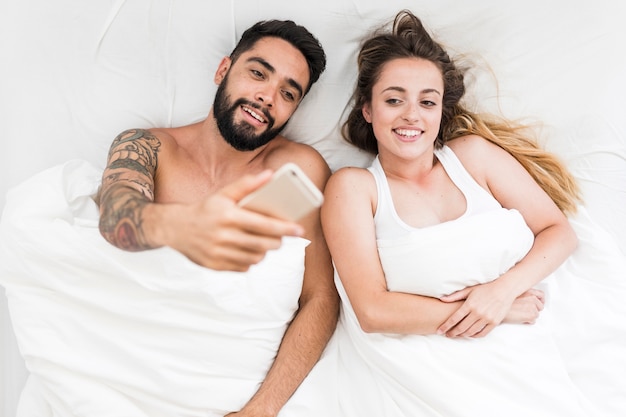 Vista elevada de una pareja joven que toma autofoto en el celular