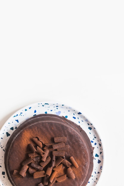 Una vista elevada de pastel de chocolate en un plato blanco sobre fondo blanco