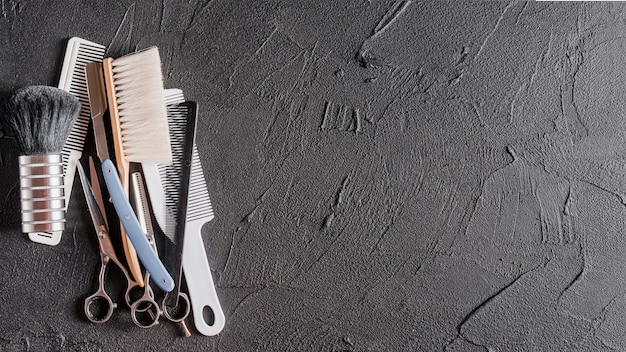 Foto gratuita vista elevada de peines, tijeras y maquinilla de afeitar en superficie negra