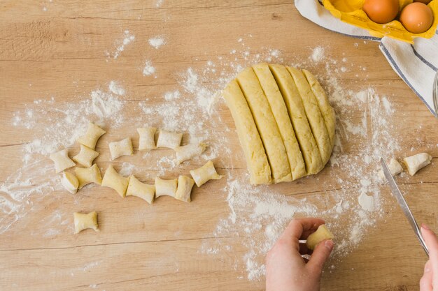 Una vista elevada de una persona que prepara los ñoquis de pasta italiana casera