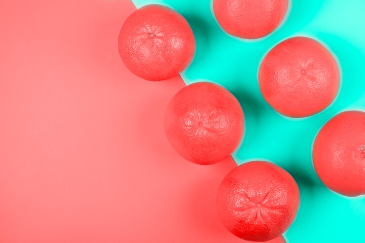 Foto gratuito una vista elevada de pomelos enteros de coral en doble fondo