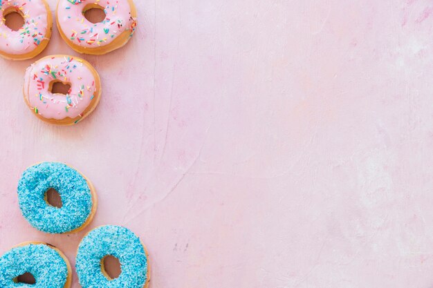 Vista elevada de rosquillas sabrosas frescas sobre fondo rosa