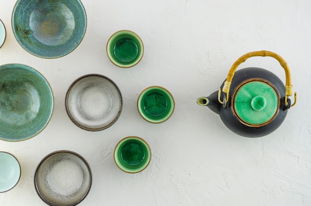 Foto gratuita una vista elevada de las tazas de té vacías con la tetera aislada en el fondo blanco