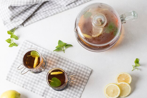 Una vista elevada de té de limón y menta sobre fondo blanco