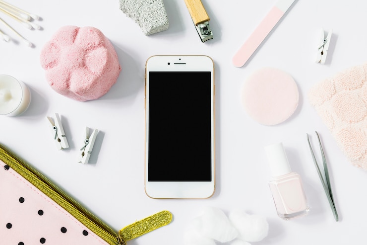 Foto gratuito vista elevada del teléfono inteligente rodeado de varios productos de spa en superficie blanca