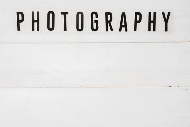 Vista elevada de texto de fotografía sobre mesa de madera blanca