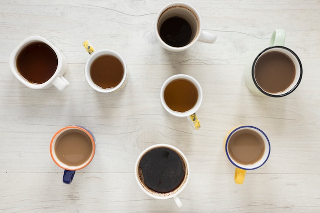 Foto gratuita vista elevada de varios tipos de café en tazas en el escritorio