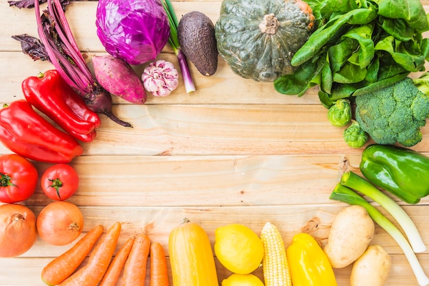 Foto gratuita vista elevada de vegetales saludables que forman un marco circular sobre fondo de madera