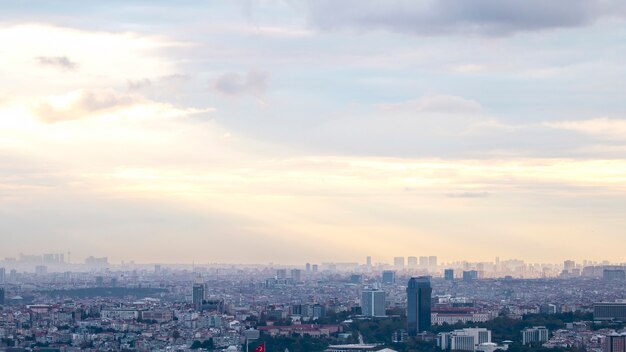 Vista de Estambul en tiempo nublado, múltiples edificios altos y bajos, niebla y luz solar rompiendo las nubes, Turquía