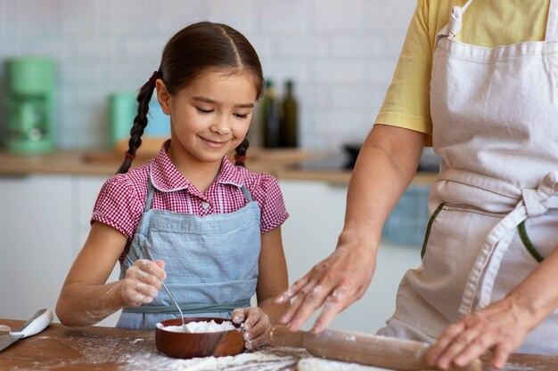 Foto gratuita vista frontal abuela y niña cocinando juntas