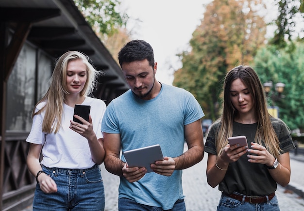 Vista frontal adolescentes revisando su mensaje en los teléfonos