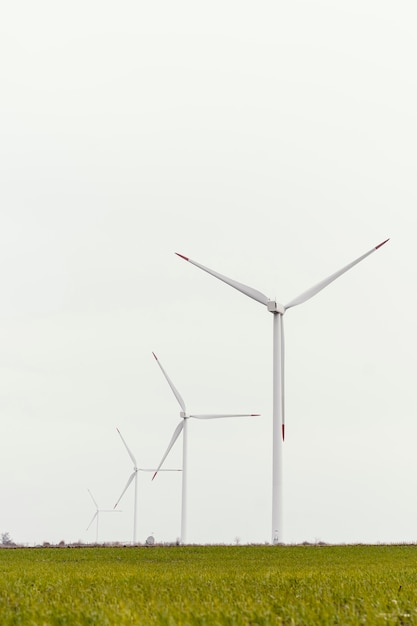 Vista frontal de aerogeneradores en el campo con espacio de copia