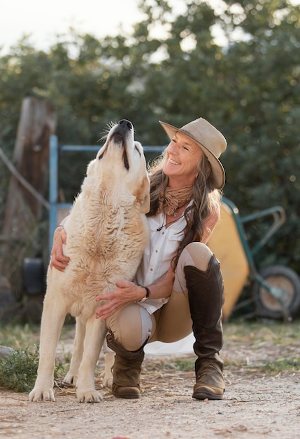 Vista frontal de la agricultora sonriente con su perro de granja