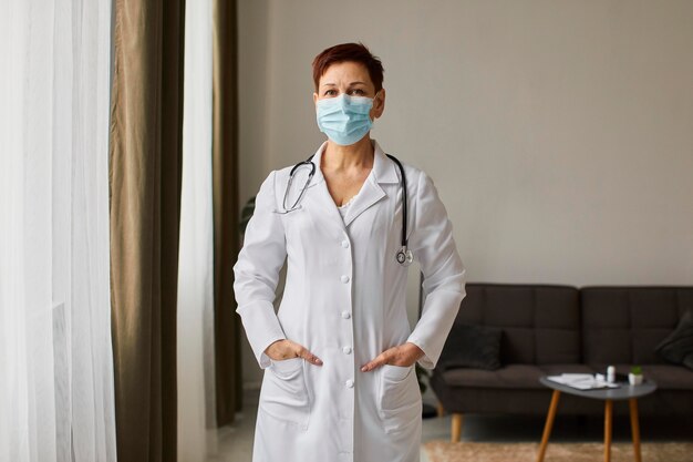 Vista frontal de la anciana doctora del centro de recuperación de covid con máscara médica