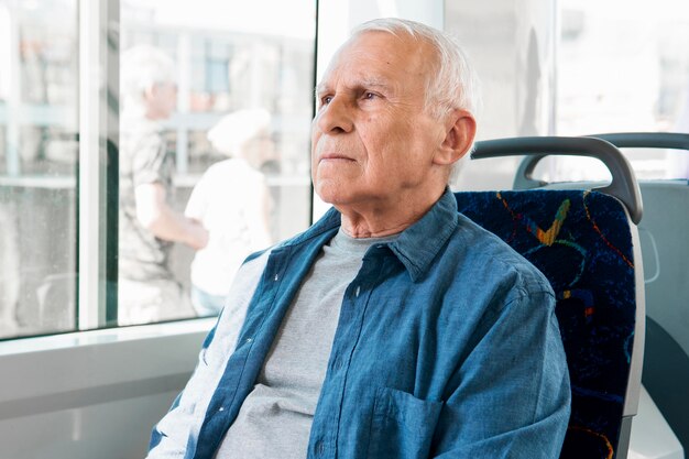 Vista frontal del anciano en transporte público