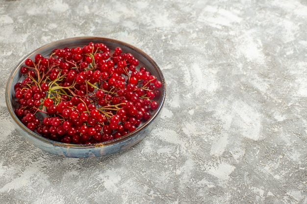 Vista frontal de arándanos rojos frescos dentro de la bandeja en la mesa de luz blanca color baya fruta roja salvaje