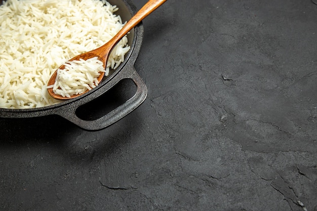 Foto gratuita vista frontal del arroz cocido dentro de la sartén en la superficie oscura comida comida arroz cena oriental