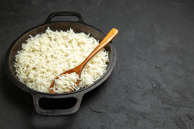 Vista frontal del arroz cocido dentro de la sartén en la superficie oscura comida comida arroz cena oriental