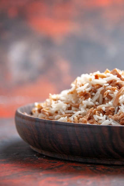 Vista frontal de arroz cocido con rebanadas de masa en la superficie oscura comida del plato comida oscura