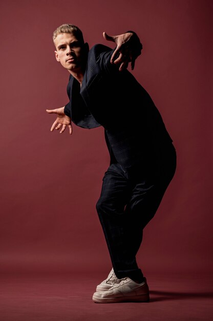 Vista frontal del artista masculino posando y bailando