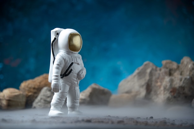Vista frontal del astronauta blanco con rocas en una luna azul ciencia ficción fantasía cósmica