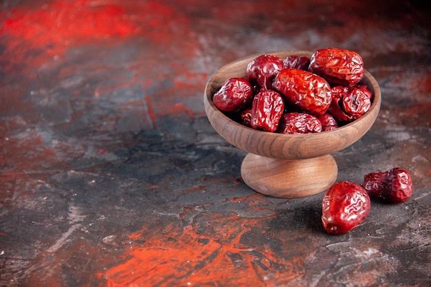 Vista frontal azufaifos rojos secos sobre fondo rojo oscuro vacaciones de frutas horizontal agrio seco