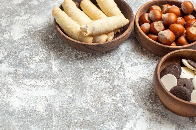 Vista frontal de bagels dulces con galletas y nueces sobre fondo blanco.