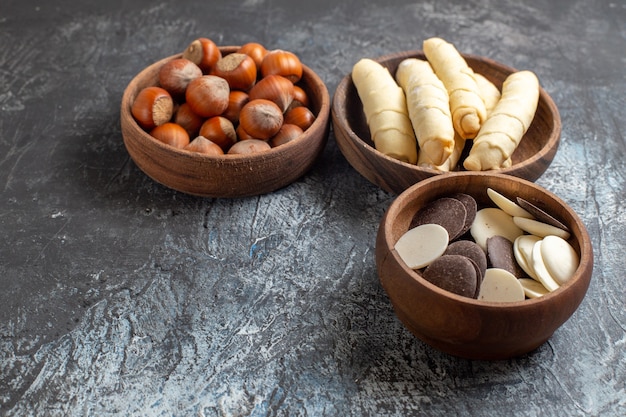 Vista frontal de bagels dulces con galletas y nueces sobre fondo oscuro