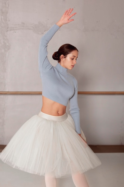 Vista frontal de la bailarina en falda tutú practicando ballet