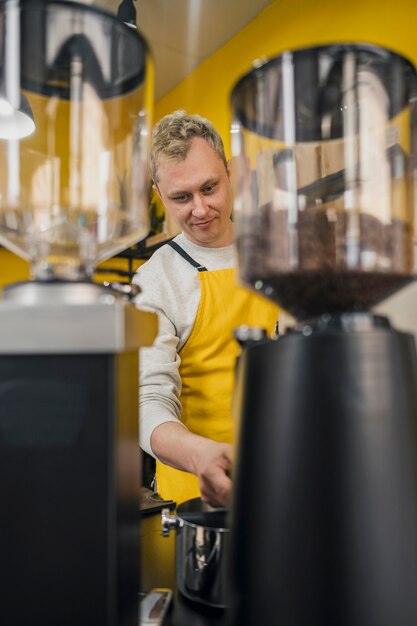 Vista frontal del barista masculino con delantal en el trabajo