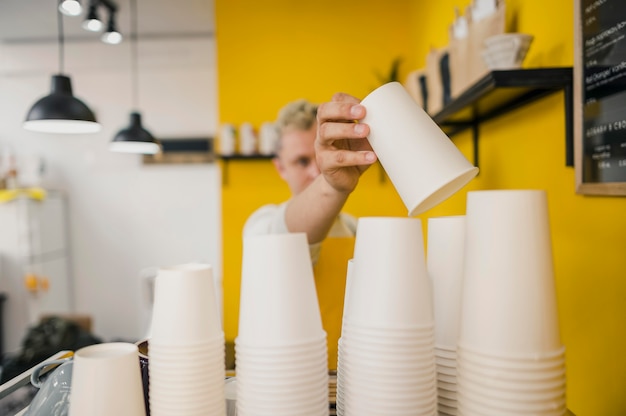 Foto gratuita vista frontal del barista masculino con tazas de café