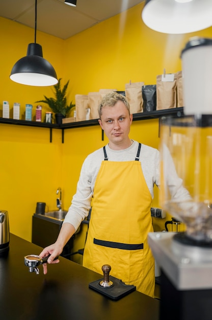 Vista frontal del barista masculino en la tienda