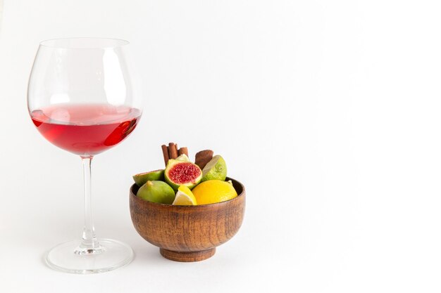 Vista frontal de la bebida de alcohol rojo dentro del vaso con higos dulces frescos en el escritorio blanco bebida de alcohol licor whisky bar
